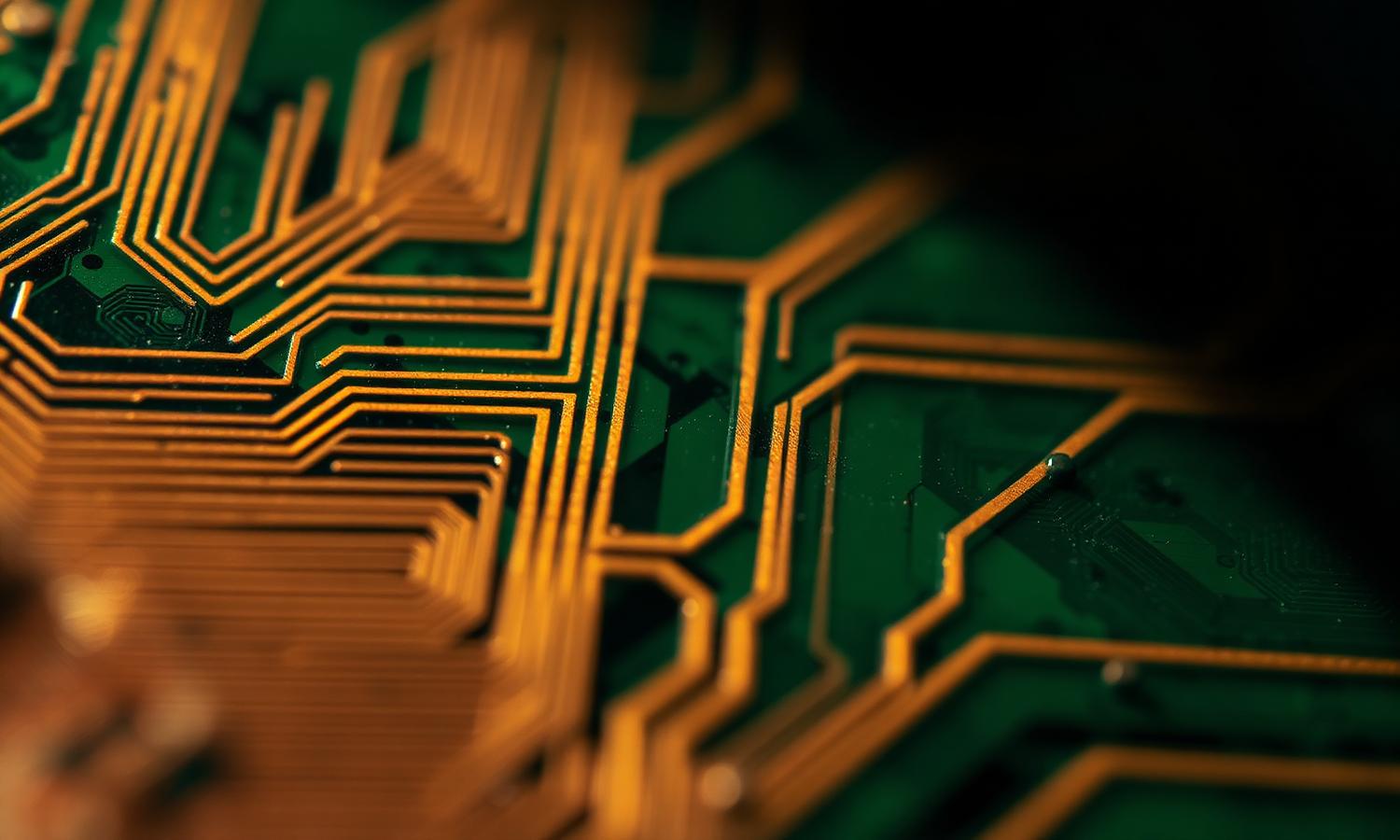 Detail of copper circuit traces on a green printed circuit board